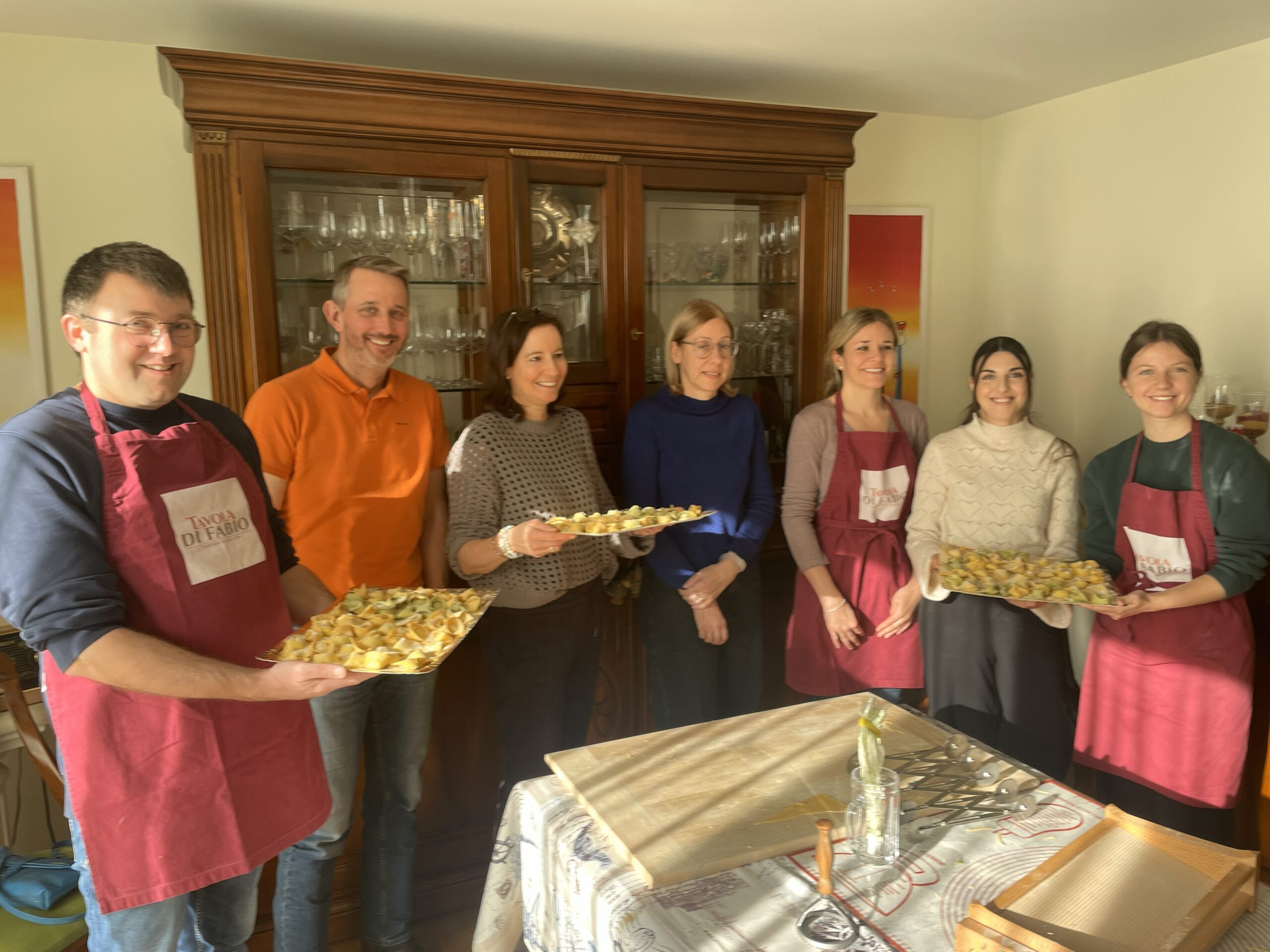 Gruppenfoto während eines Kochkurses in Basel bei Tavola di Fabio mit frisch zubereiteten, handgemachten Tortelloni aus dem Pasta-Workshop.