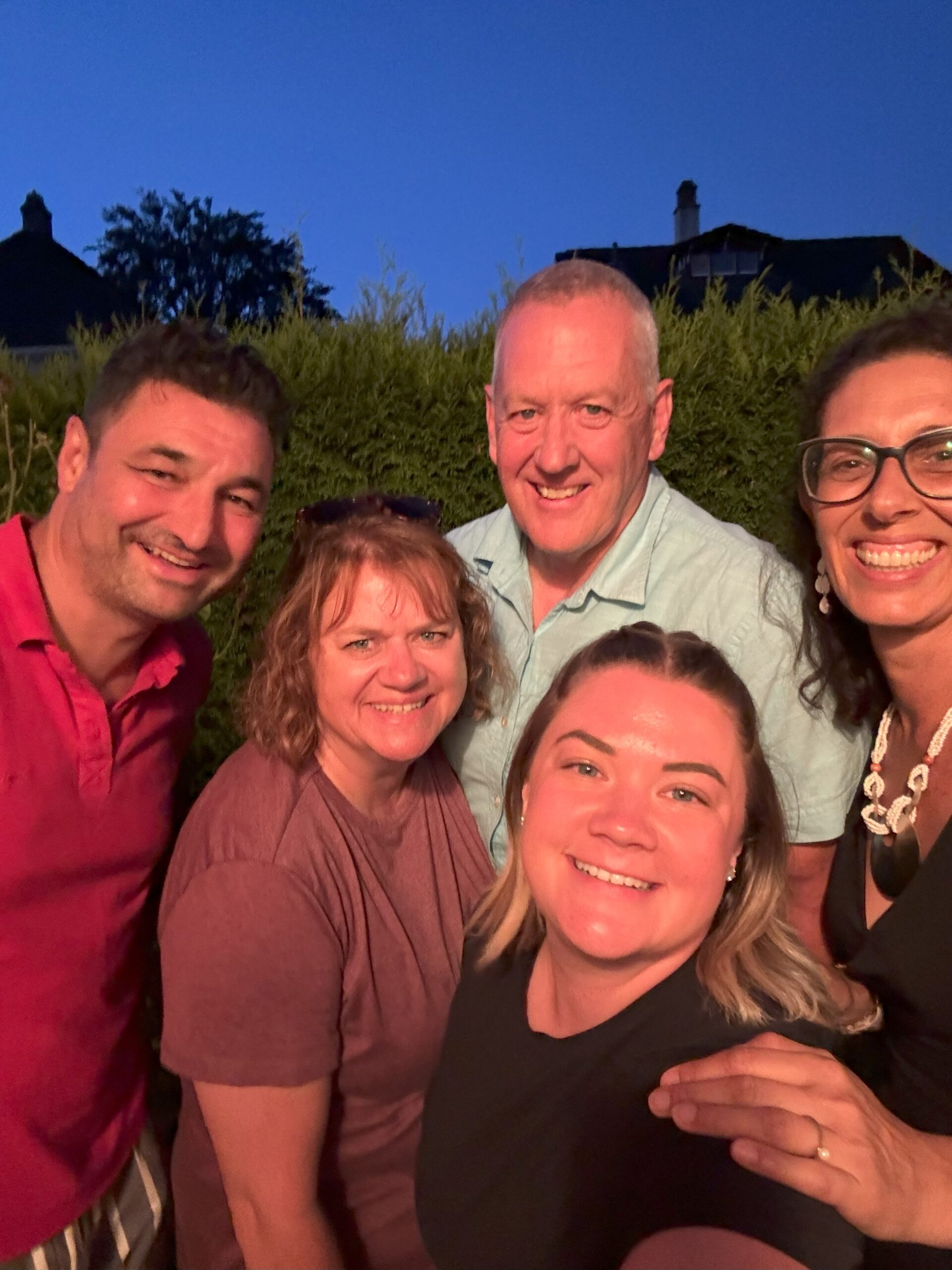 Vier Teilnehmende in Kochschürzen posieren lächelnd während eines gemeinsamen Kochkurses.